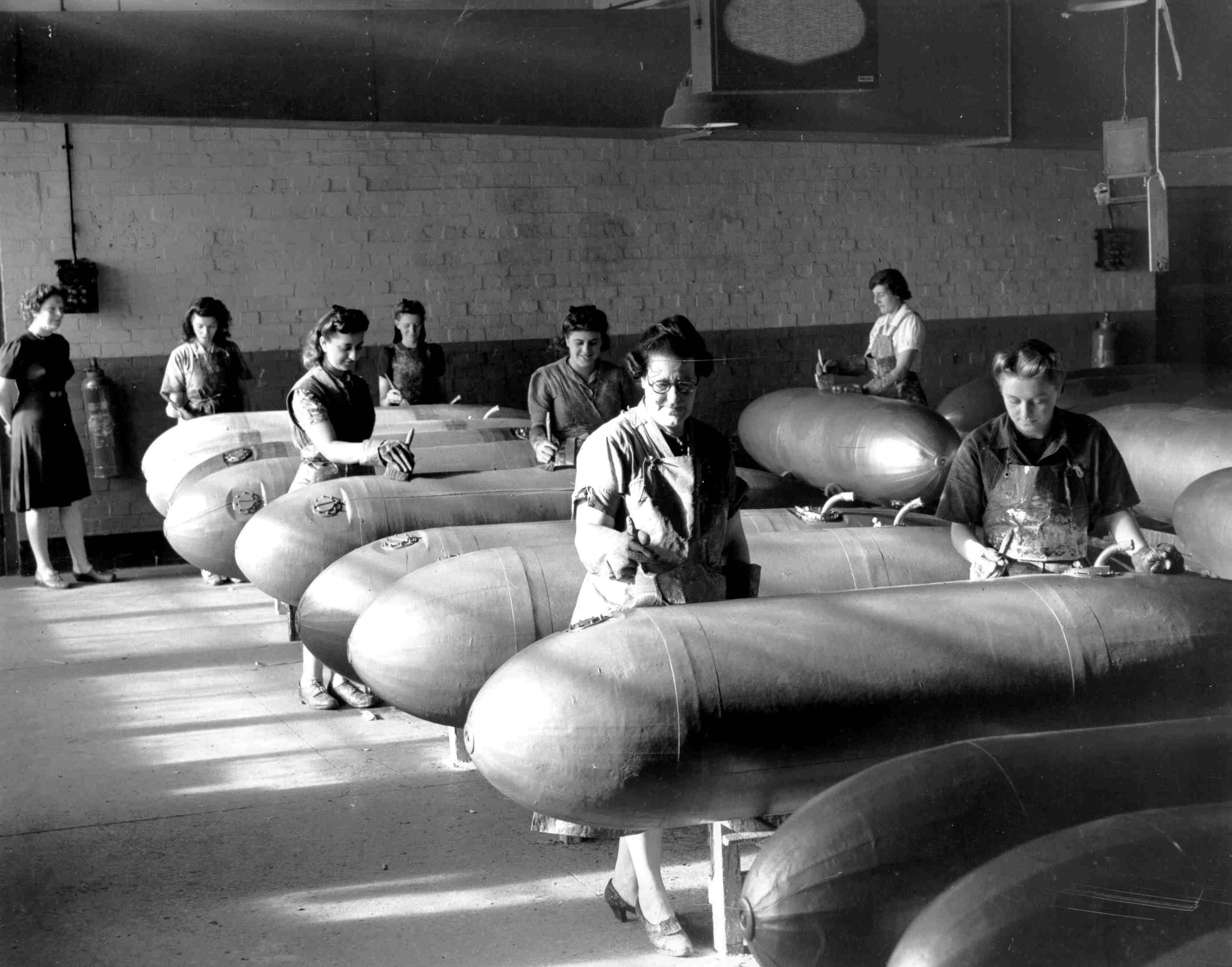 A black and white photograph of women in a factory making long range fuel drop tanks.