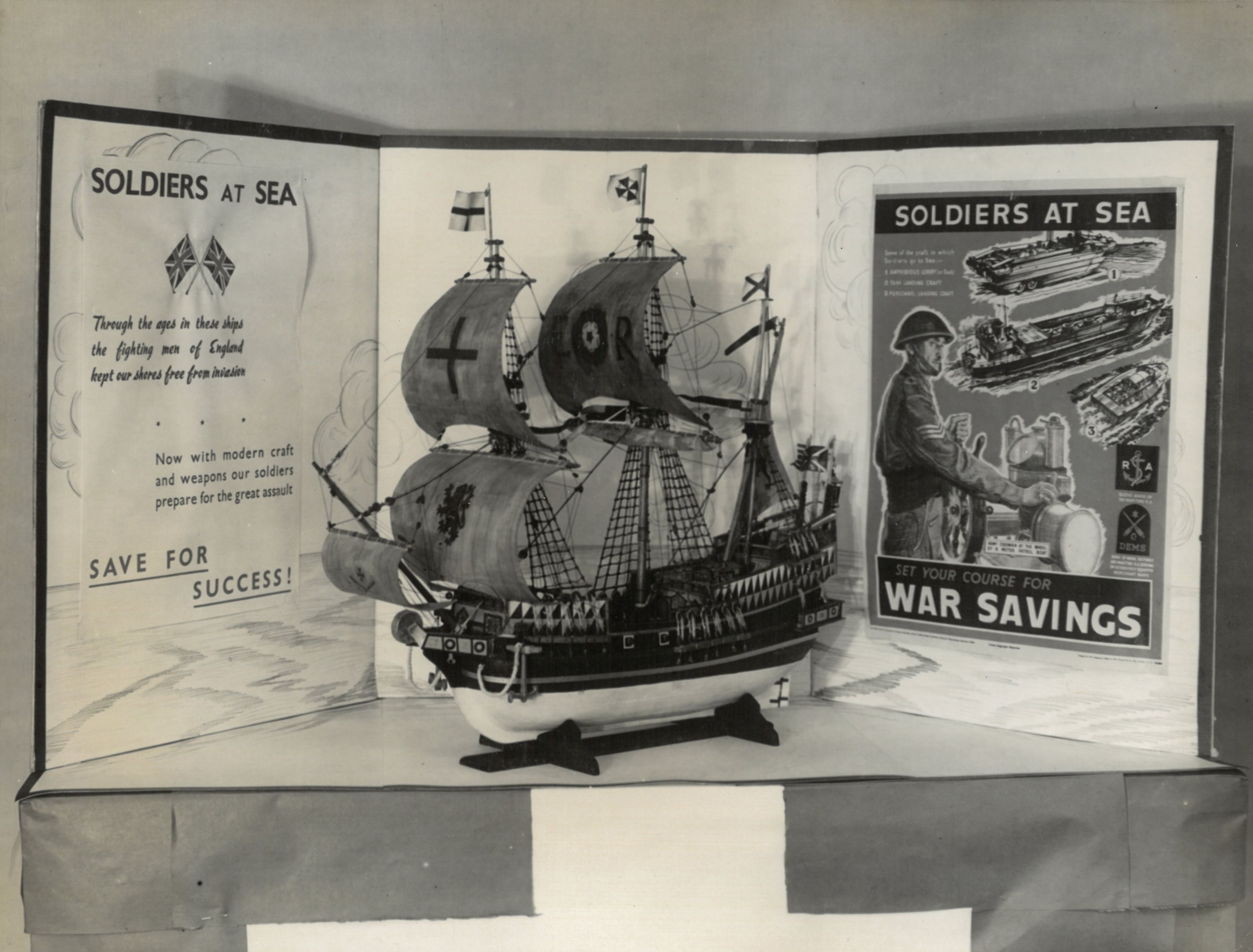 A black and white photograph of a fundraising display for Soldiers at Sea, with a large model boat with sails in the centre.